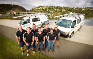 plumbers in Bellevue, WA pose with work vans